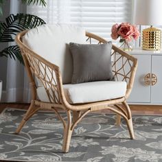 a wicker chair sitting on top of a rug next to a lamp and flowers