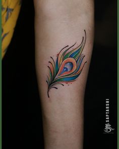 a colorful peacock feather tattoo on the arm