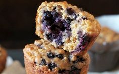 blueberry muffins stacked on top of each other with one bite taken out