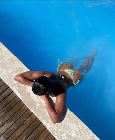 a woman swimming in a pool with her back to the camera