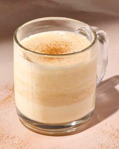 a glass mug filled with liquid sitting on top of a table