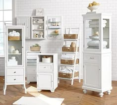 a bathroom with white furniture and wooden floors