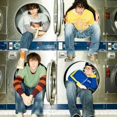 four men sitting in front of washing machines