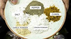 a person holding a white plate with spices on it and the words pepper salt cumin garlic powder onion powder