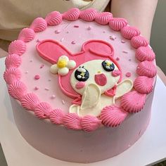 there is a cake decorated with pink icing and an image of a bunny on it