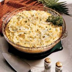 a casserole dish with broccoli and cheese in it on a table