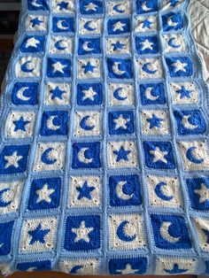 a blue and white crocheted afghan with stars and crescents on the edges