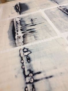 an abstract painting with black and white paint on the ground in front of a building