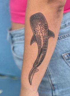 a woman's arm with a tattoo on it that has a dolphin in the middle