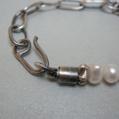 "Oxidized sterling silver chain bracelet and pearls, it is part of the \"Rock\" series, take a look at the others too! The bracelet is composed of a part made of silver with long, rectangular and flat hammered links; and from a string of pearls, with variable dimensions up to 8 mm. The rings, the terminal cylinders, the spacers, and the pendants are all in sterling silver and handcrafted. weight: 14 g length 18.5 cm It is a light, original bracelet, beautiful to always wear, alone or combined wi Everyday Minimalist Pearl Bracelet With Metal, Everyday Minimalist Pearl Bracelet, Minimalist Metal Pearl Bracelet, Modern Silver Pearl Bracelet With Oyster Design, Elegant Oxidized Link Bracelets, Elegant Link Bracelet With Oxidized Finish, Minimalist Sterling Silver Pearl Chain Bracelet, Elegant Handmade Sterling Silver Oval Link Bracelet, Minimalist Sterling Silver Pearl Bracelet