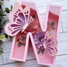 a pink box with paper flowers and butterflies in it