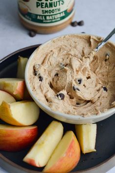 a bowl of peanut butter and apples on a plate