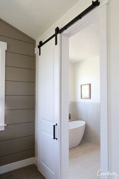 an open door leading to a bathroom with a tub