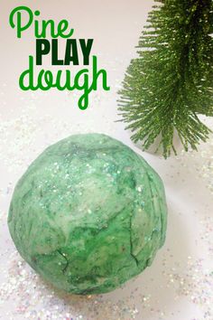 a green play dough sitting next to a pine tree