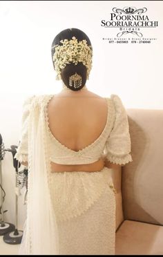 the back of a woman's head wearing a white dress with flowers on it