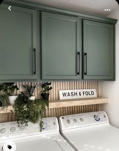 a washer and dryer in a room with green cabinets