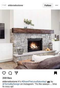 a living room with a fire place and couches in front of the tv on the wall