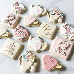 many decorated cookies are arranged on a white table top with the words tea time spelled in cursive letters