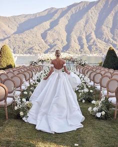 a woman in a white wedding dress standing next to rows of chairs