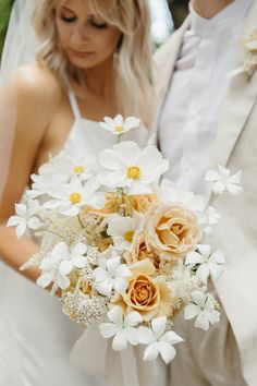 the bride and groom are standing close together