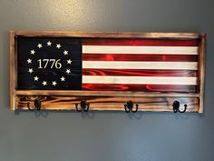 an american flag hanging on a wall with hooks