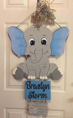 a door hanger with an elephant holding a sign that says brainy storm