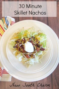 a white plate topped with a salad covered in sour cream and other toppings on top of it