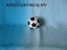 a small black and white soccer ball sitting on top of a blue cloth covered sheet