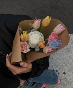 a woman holding a bouquet of flowers in her hands