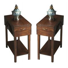 two wooden side tables with one drawer open and the other closed, both holding a silver vase