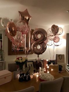 a table with balloons that say 8 in the middle