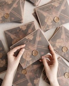 a person is placing coins on top of some envelopes that are being held by their hands