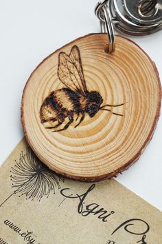 a wooden keychain with a bee on it