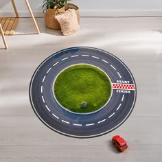 a toy car is on the road with green grass