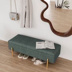 a green bench sitting under a mirror next to a coat rack with shoes on it