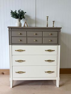 a white and grey dresser with two vases on top