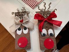 two paper bags with reindeer noses and bows on them are sitting on the floor next to each other