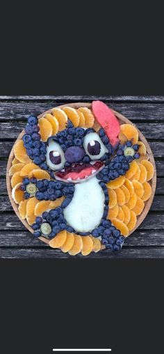 an image of a cake made to look like a cartoon character with fruit on it