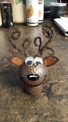 a close up of a cupcake shaped like a deer on a counter with other items in the background