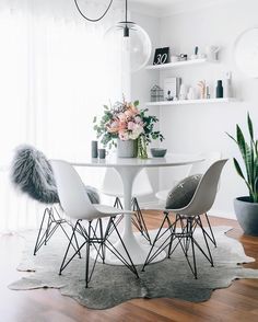 a white dining table with four chairs around it