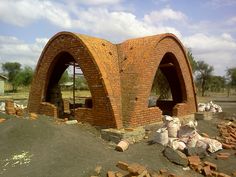 a brick building with two arched windows and bricks around it