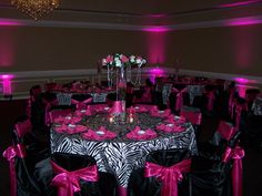 the tables are decorated with zebra print and pink sashes