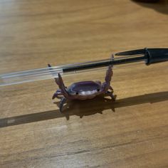 a plastic crab sitting on top of a wooden table