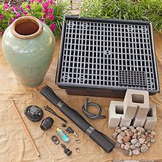 an assortment of garden tools sitting on top of a table next to a potted plant