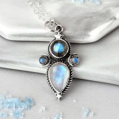 This mystical and celestial necklace will add a touch of magic to your look! Made with Labradorite and Moonstone gems, this sterling silver necklace features crescent moons and stars inspired by the cosmos. Labradorite can symbolize self-love, spiritual protection and intuition. As well, Moonstone can symbolize the divine feminine, clarity, intuition and the moon phases. *Our jewelry features natural, genuine gemstones, ensuring each piece is unique and one-of-a-kind. Please note that, as no two Bohemian Moonstone Jewelry With Moon Phase Detail, Bohemian Moonstone Jewelry With Moon Phase, Celestial Silver Labradorite Jewelry, Celestial Moon Phase Necklace In Labradorite, Celestial Silver Moonstone Necklace, Celestial Silver Gemstone Necklace, Celestial Silver Necklace With Gemstone, Silver Celestial Moonstone Necklace, Bohemian Silver Labradorite Necklaces