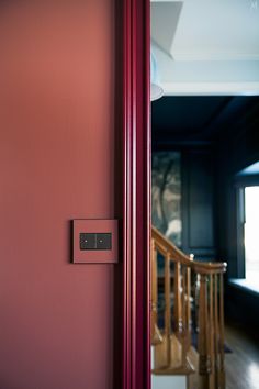 a red door with a light switch on it