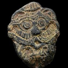 an ancient object with a face on it