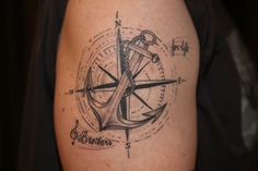 an anchor and compass tattoo on the arm