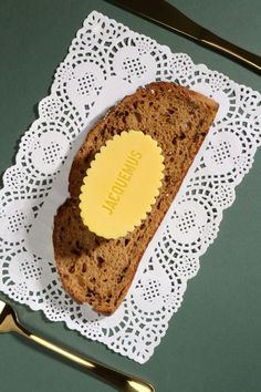 a piece of bread with a yellow sticker on it sitting on top of a doily