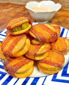 there is a plate full of fried pickles on the table next to some dipping sauce